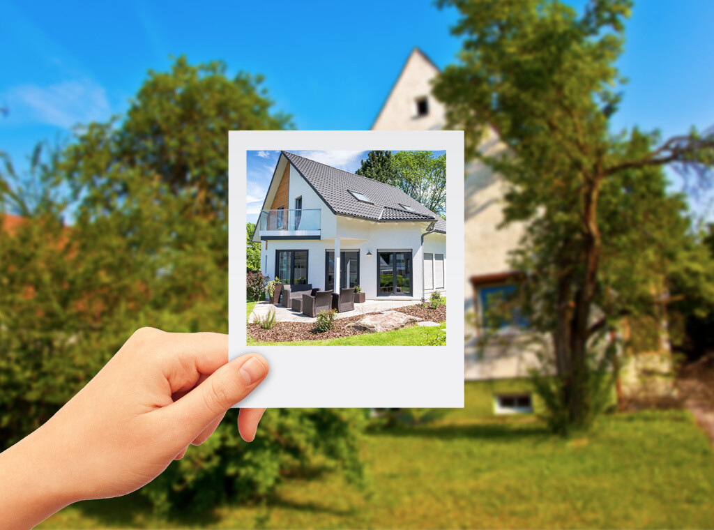 Polaroid-Foto, das vor eine Immobilie gehalten wird.