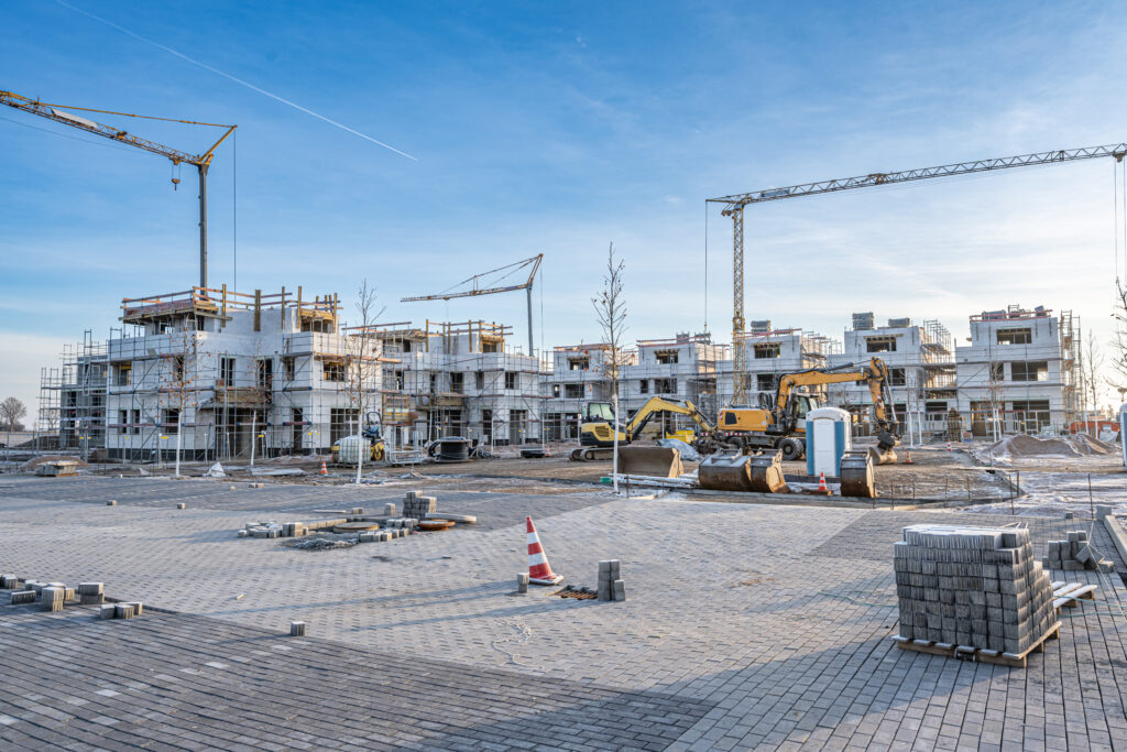 Baustelle mit Kränen, auf der mehrere Immobilien gebaut werden
