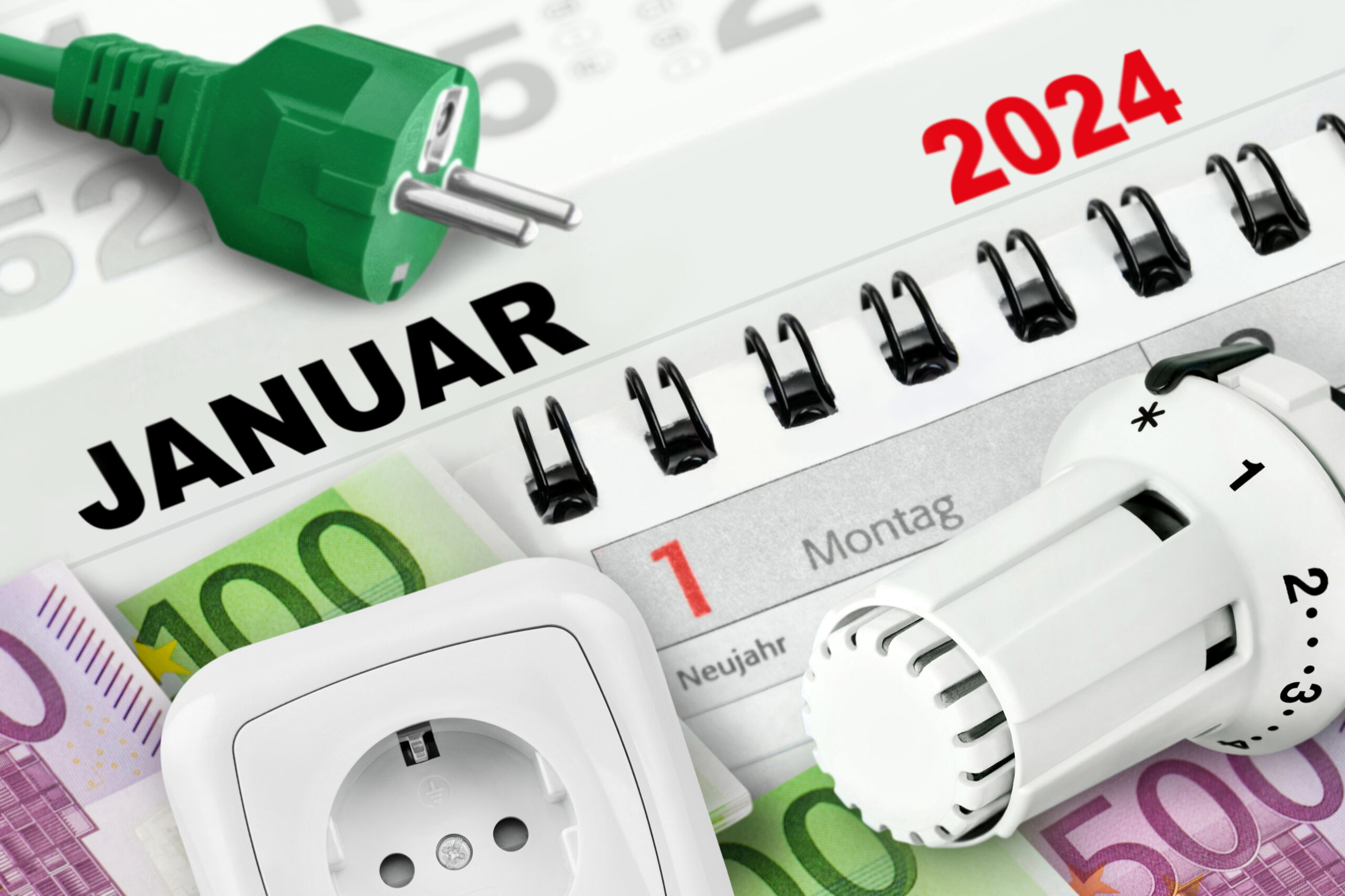 Blick auf einen Kalender, ein Thermostat, eine Steckdose und einen Stecker